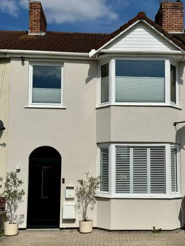 Refurbished house exterior with smooth render and black front door