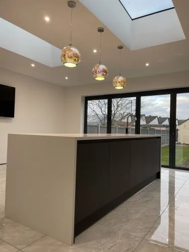 Open-plan extension with kitchen island, roof lights and sliding doors